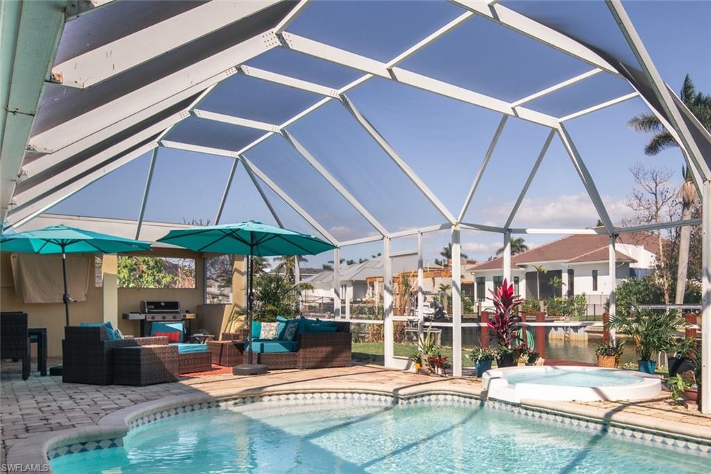 2155 Tarpon Road Naples, FL 34102 - Photo 6 of 27 a view of a patio with a table and chairs under an umbrella