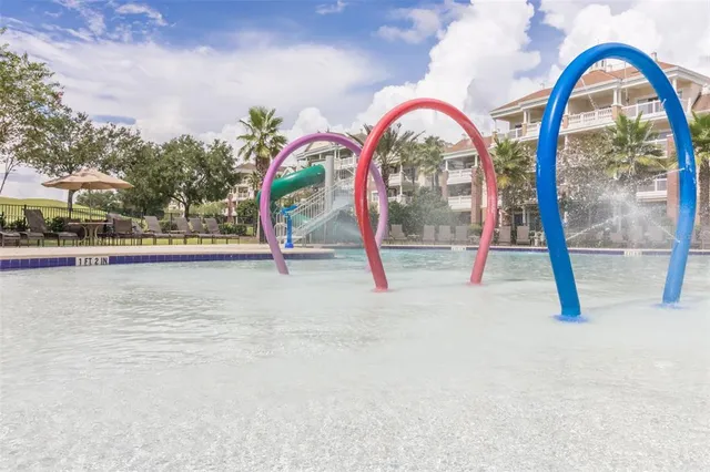 a park view with a fountain and large trees