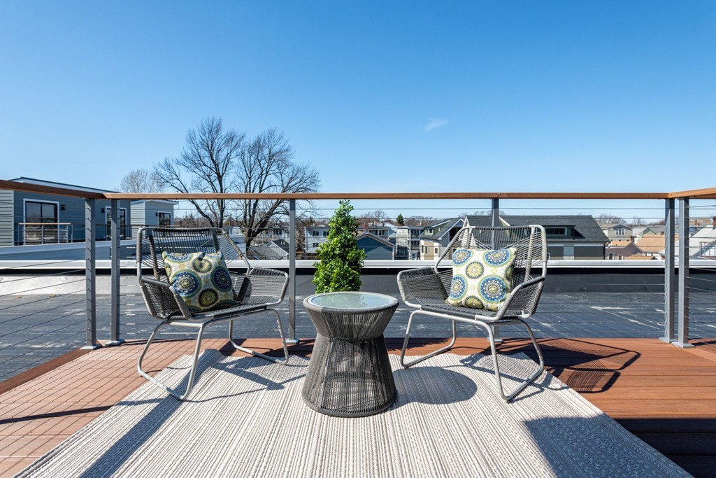 227 Cedar Street, Unit 6 Somerville, MA 02145 - Photo 21 of 25 a view of a balcony with chairs and wooden floor