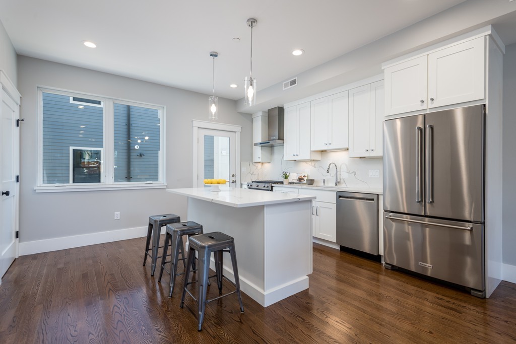 227 Cedar Street, Unit 6 Somerville, MA 02145 - Photo 5 of 25 a kitchen with a refrigerator a sink cabinets and wooden floor