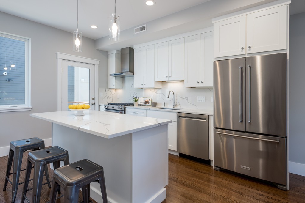 227 Cedar Street, Unit 6 Somerville, MA 02145 - Photo 6 of 25 a kitchen with refrigerator cabinets and wooden floor