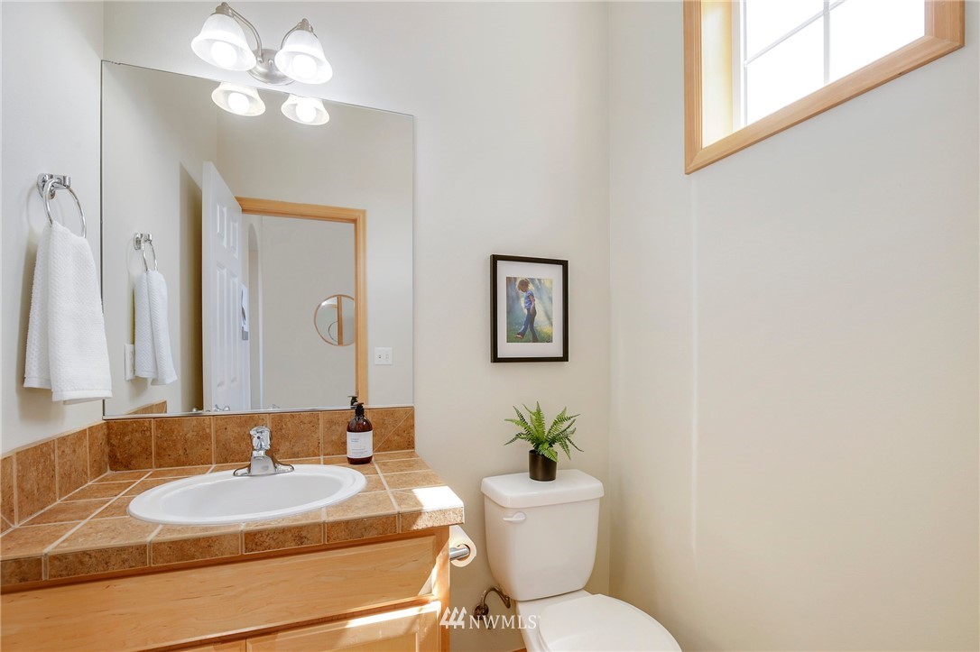 4408 Northeast 3rd Lane Renton, WA 98059 - Photo 11 of 25 a bathroom with a granite countertop toilet a sink and a mirror