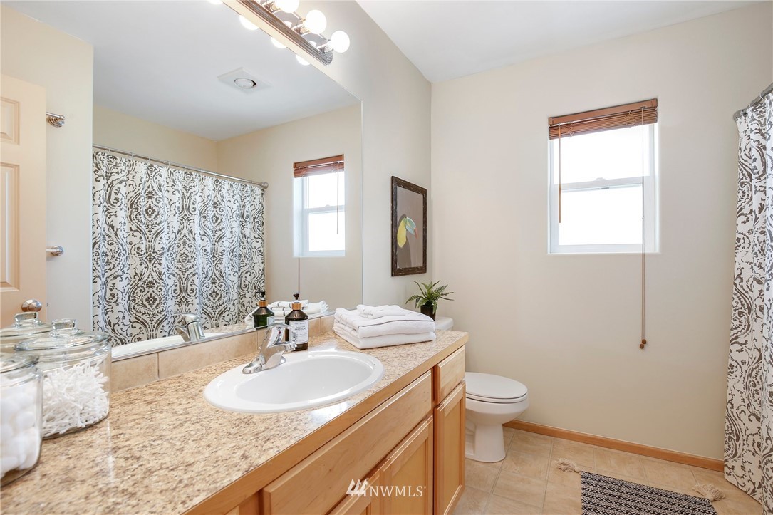 4408 Northeast 3rd Lane Renton, WA 98059 - Photo 19 of 25 a bathroom with a granite countertop sink a toilet and a mirror