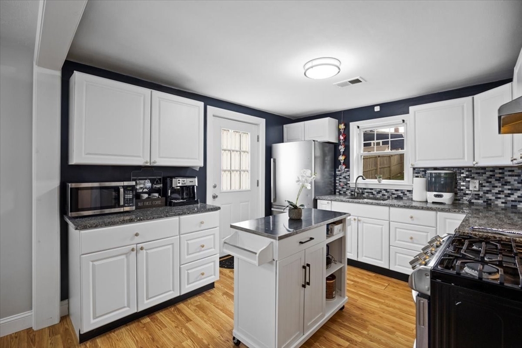 4 Webster Street Randolph, MA 02368 - Photo 15 of 32 a kitchen with granite countertop a sink stove and cabinets