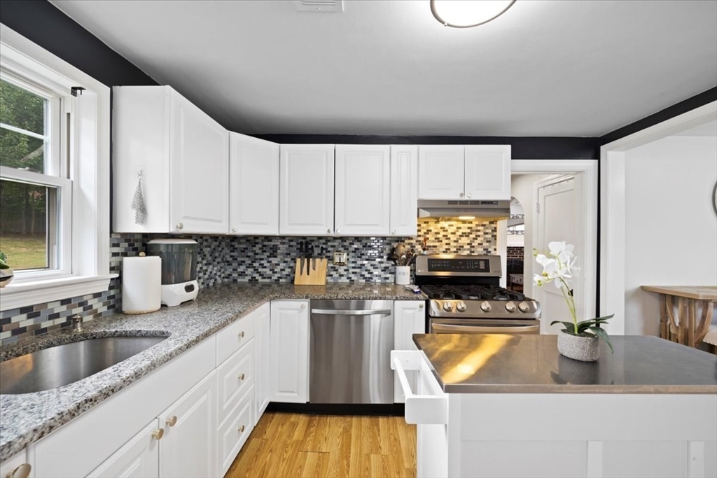 4 Webster Street Randolph, MA 02368 - Photo 17 of 32 a kitchen with kitchen island granite countertop a sink a stove and cabinets
