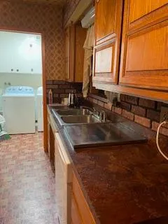 a kitchen with granite countertop a refrigerator stove top oven dining table and chairs
