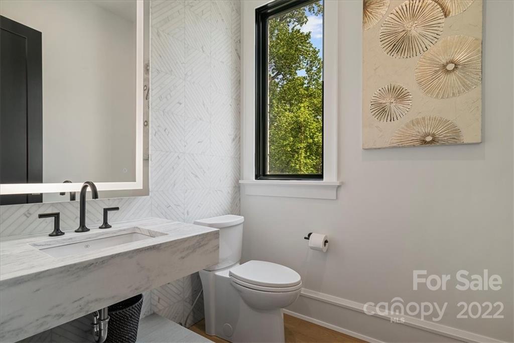 616 Queens Road Charlotte, NC 28204 - Photo 16 of 38 a bathroom with a toilet a sink and a window