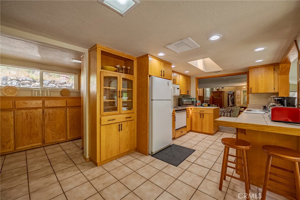 9977 Incline Road El Portal, CA 95318 - Photo 26 of 46 a kitchen with stainless steel appliances kitchen island granite countertop a refrigerator and a sink