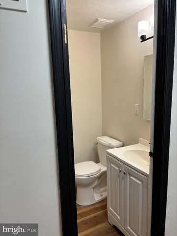 a bathroom with a sink a toilet a rug and a window