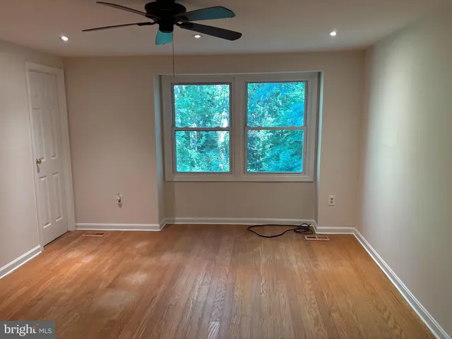 an empty room with a window and a ceiling fan