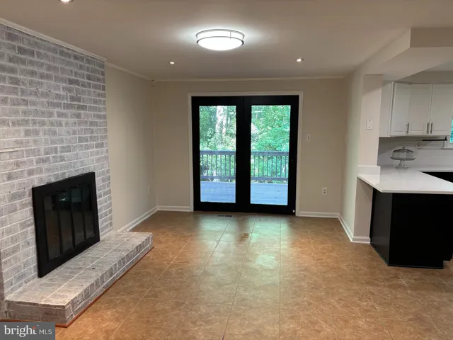 a view of an empty room with a fireplace and a window
