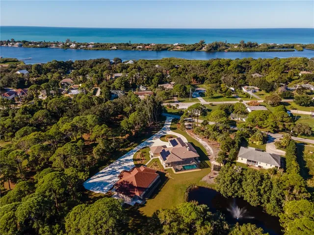 a view of a white house with a yard and plants