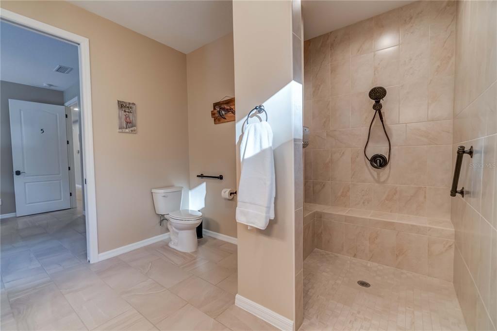 1991 Heasley Road Englewood, FL 34223 - Photo 64 of 70 a bathroom with a granite countertop toilet a sink and shower