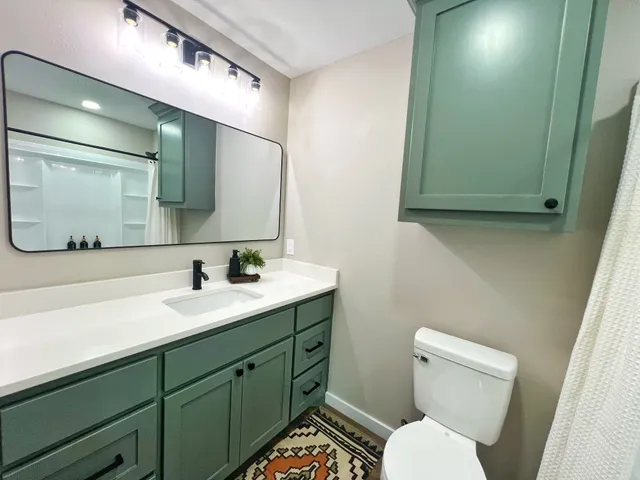 a bathroom with a toilet sink and mirror