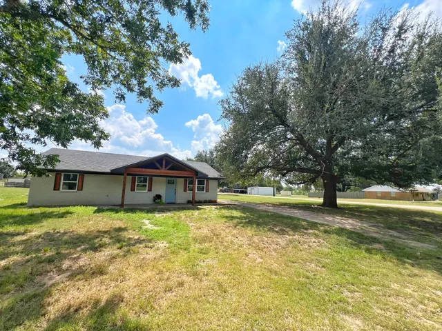a white house that has a tree in front of it