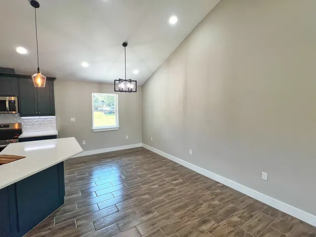 a view of a kitchen with a sink and dishwasher with wooden floor