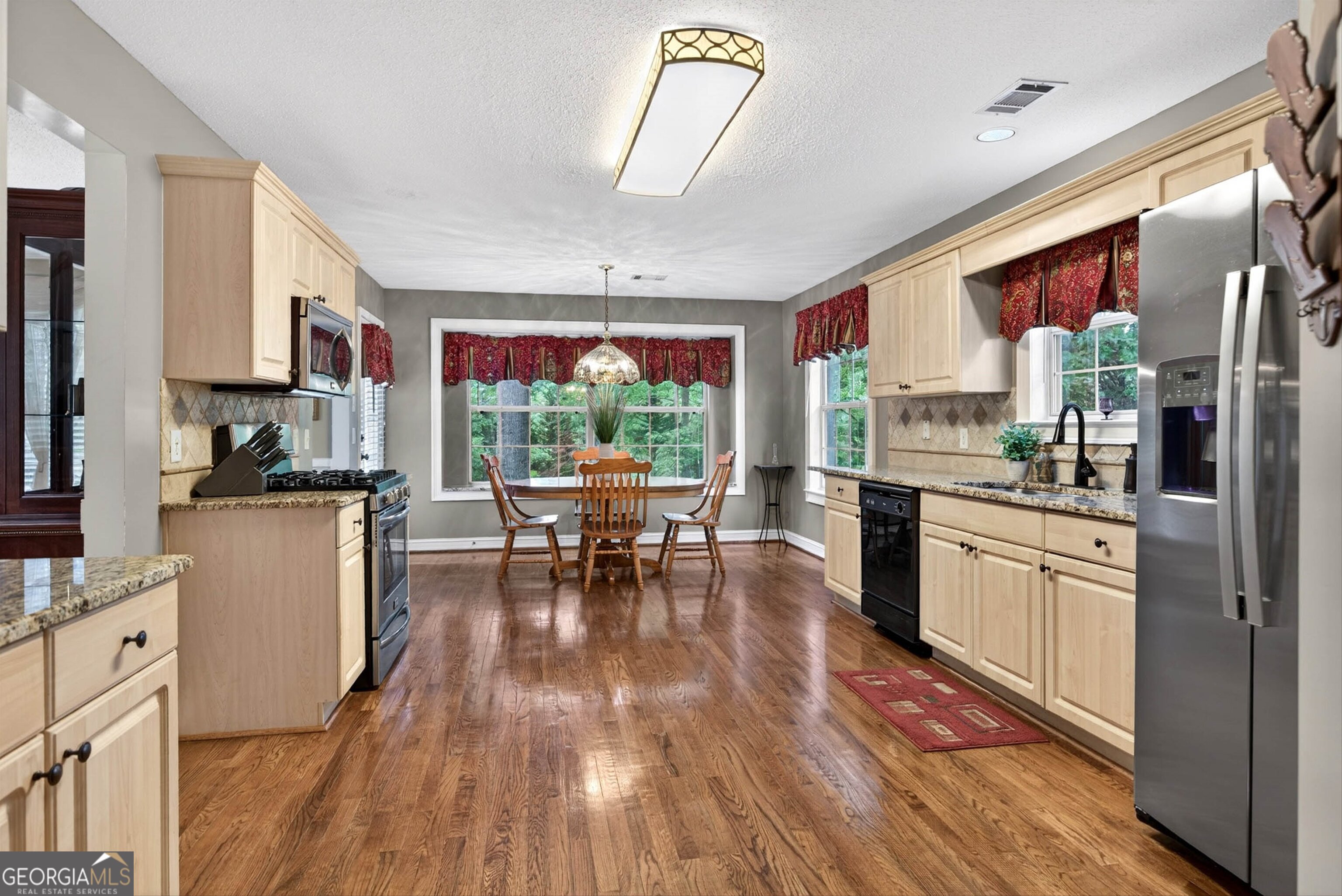 101 Emerald Lane Hampton, GA 30228 - Photo 21 of 72 a kitchen with stainless steel appliances granite countertop a stove a refrigerator a kitchen island a stove and a wooden floors