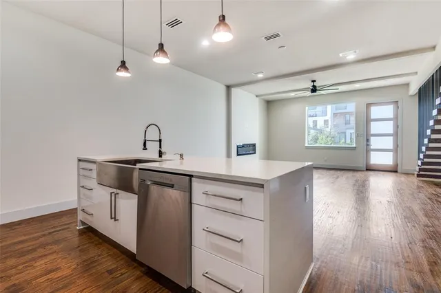 a kitchen with a sink and wooden floor