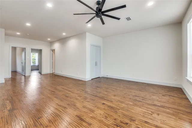 a view of a room with wooden floor and a ceiling fan