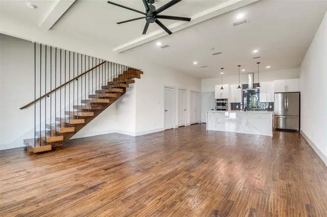 a view of staircase and kitchen with wooden floor and electronic appliances