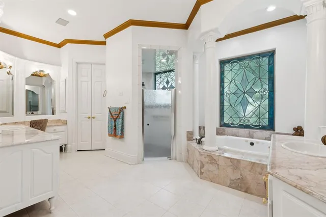 a bathroom with a tub a double vanity sink and mirror