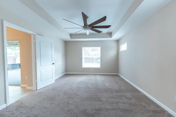 an empty room with a window and a fan
