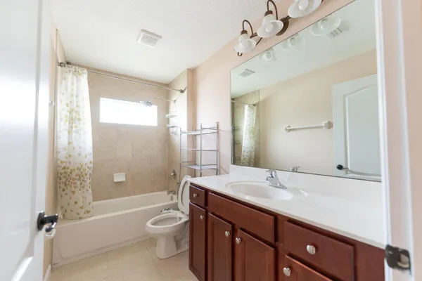 a bathroom with a double vanity sink toilet mirror and bathtub