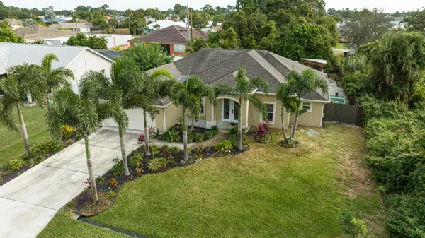 an aerial view of residential houses with outdoor space and trees