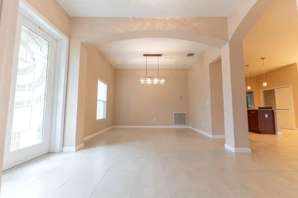 a view of a big room with windows and chandelier