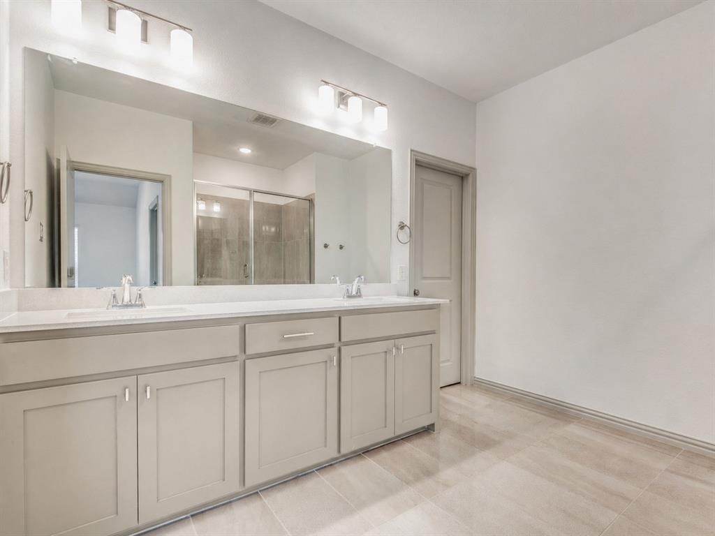 8913 Swallowtail Street Frisco, TX 75035 - Photo 27 of 38 a bathroom with double sink and a mirror