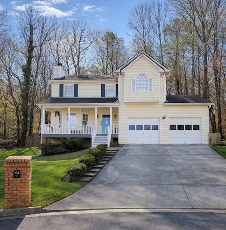 a view of house with yard and tree in front of it