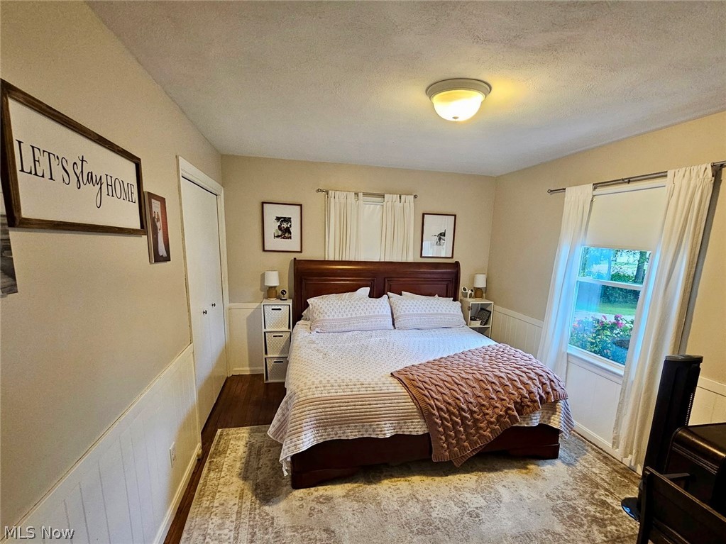 6620 West Lake Road Vermilion, OH 44089 - Photo 28 of 34 Wood-finish flooring with an area rug, white wainscoting, and a flush-mount ceiling light