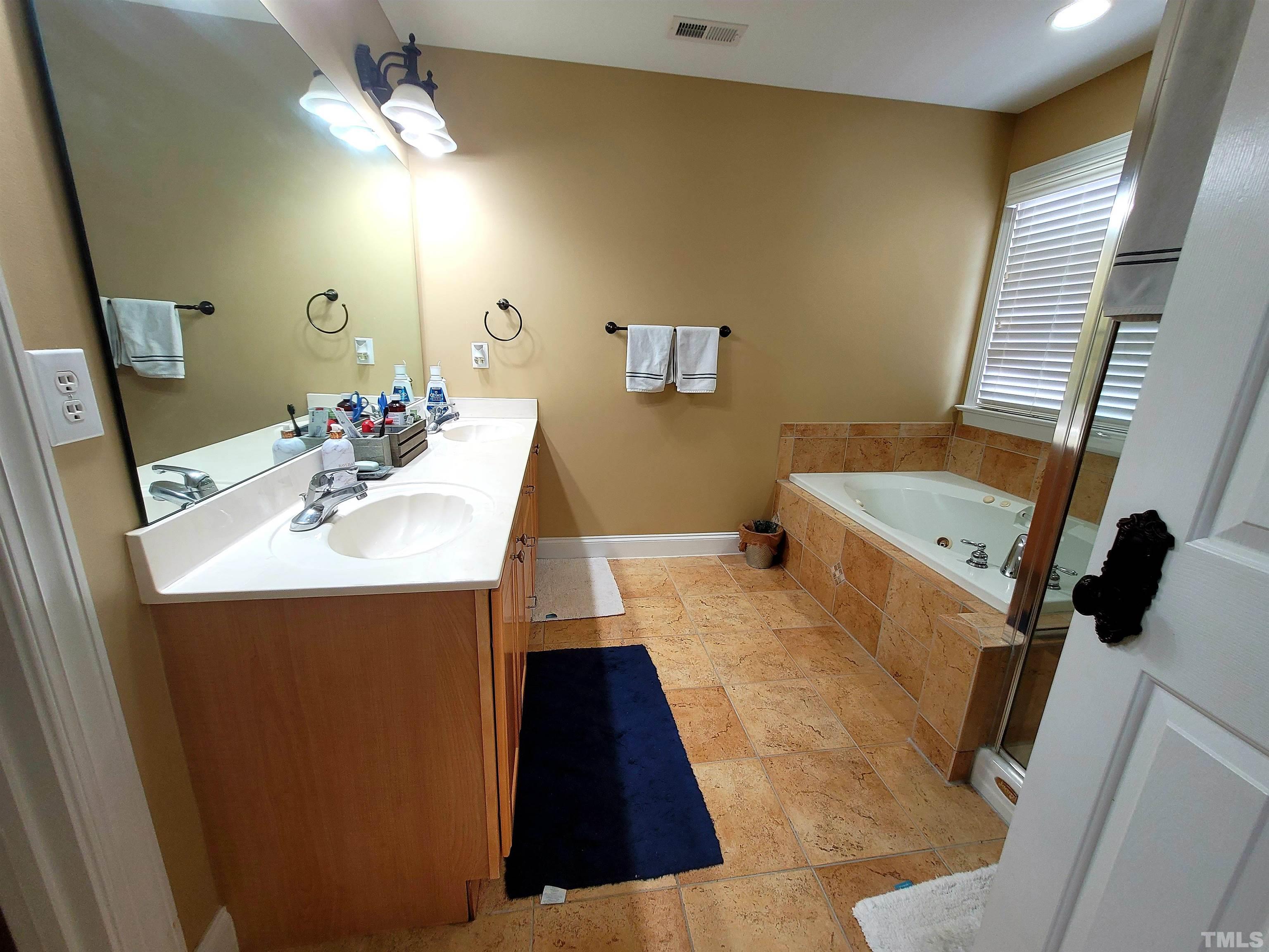 411 Magdala Place Apex, NC 27502 - Photo 17 of 29 a bathroom with a sink mirror and vanity