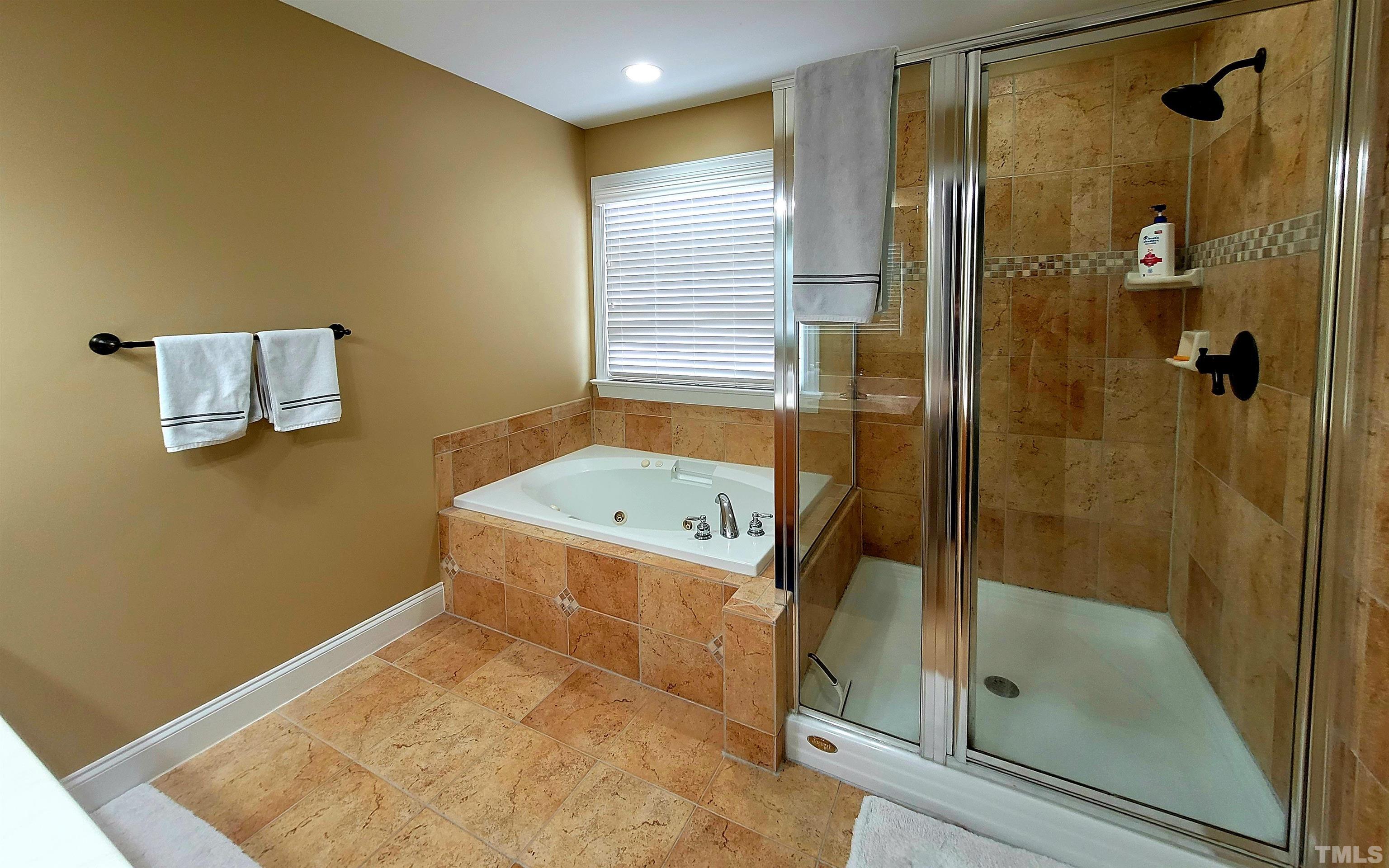 411 Magdala Place Apex, NC 27502 - Photo 18 of 29 a bathroom with a tub and a shower