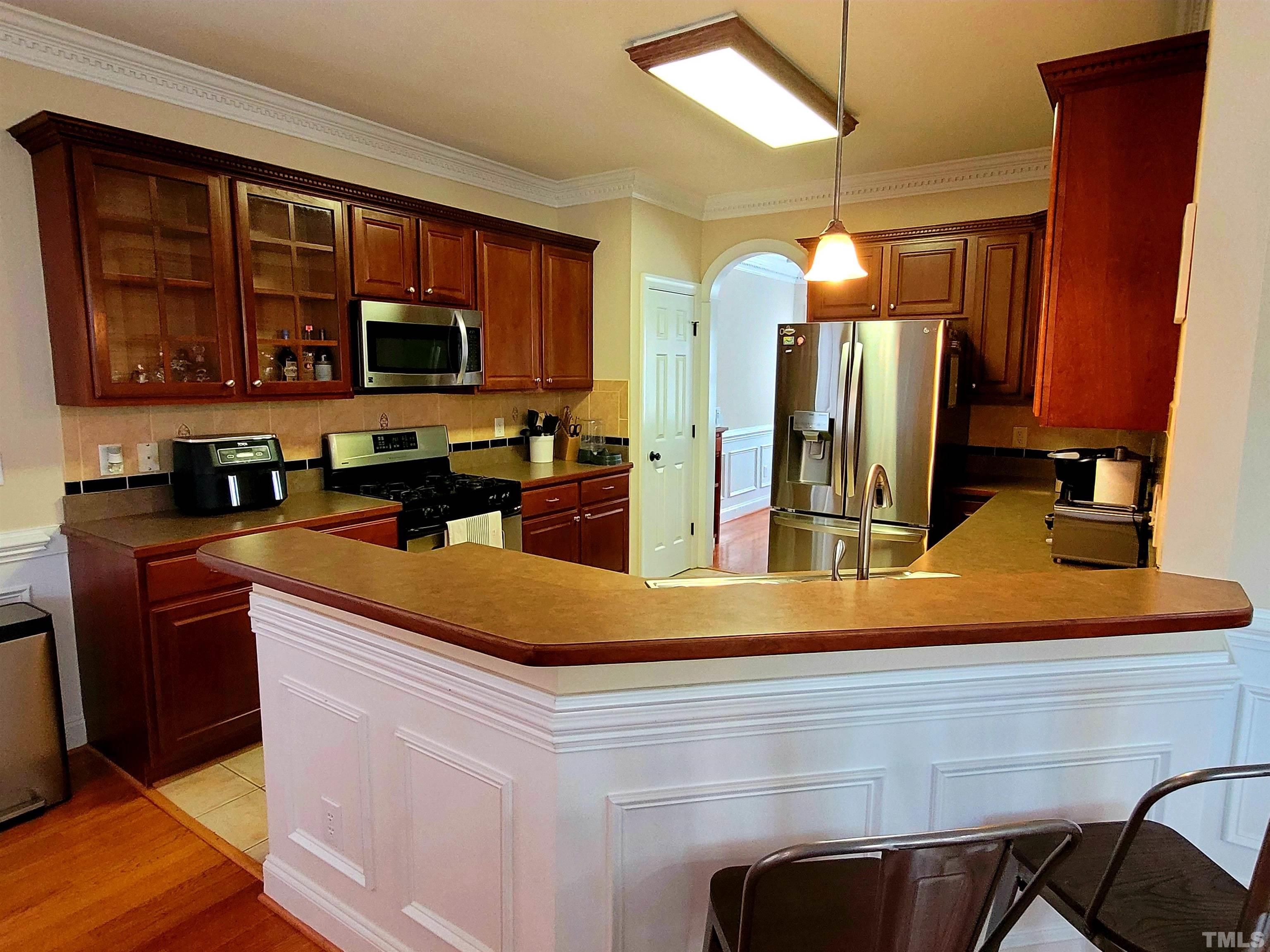 411 Magdala Place Apex, NC 27502 - Photo 20 of 29 a kitchen with stainless steel appliances granite countertop a sink and a stove