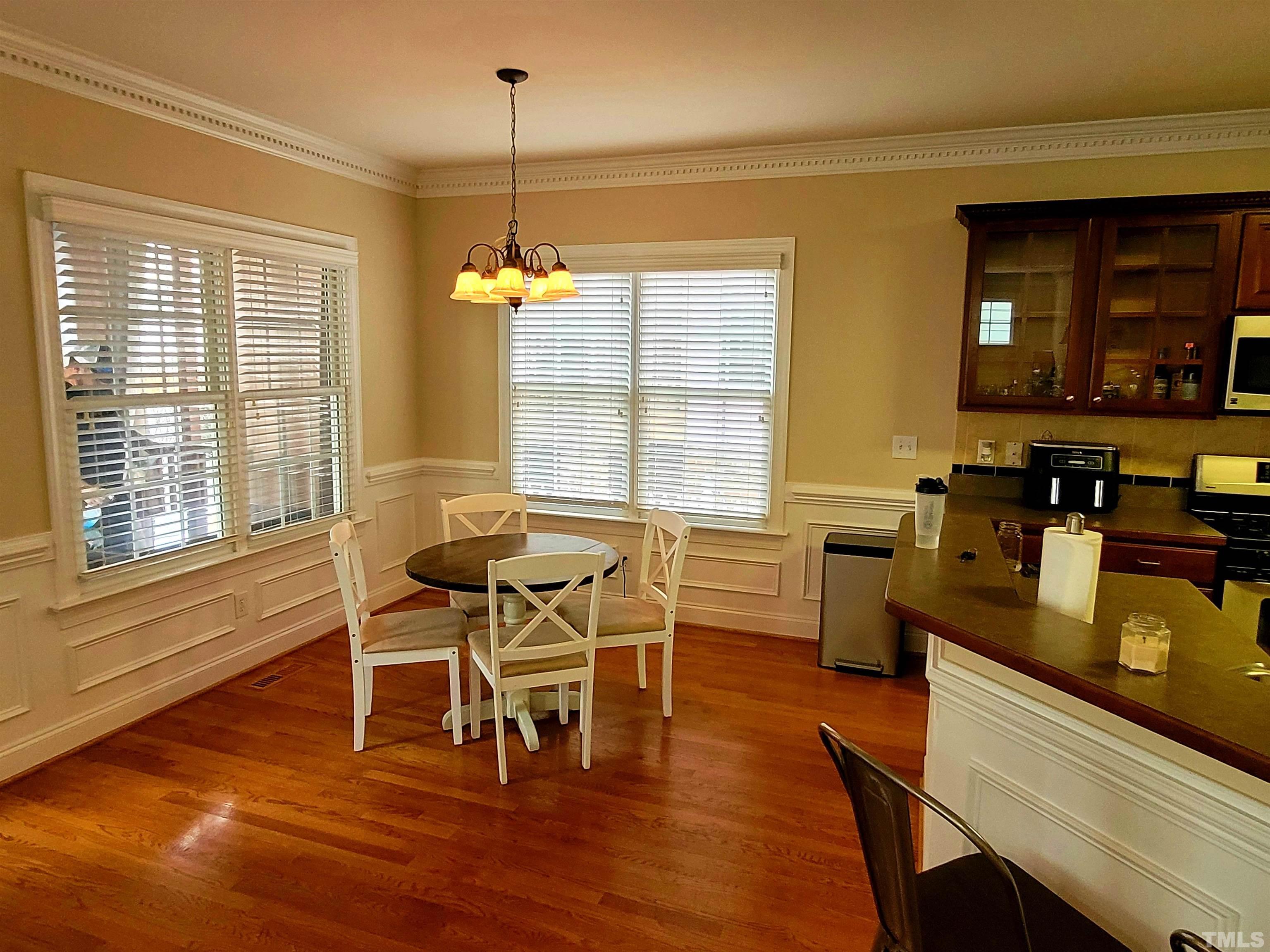 411 Magdala Place Apex, NC 27502 - Photo 23 of 29 a dining room with furniture and wooden floor