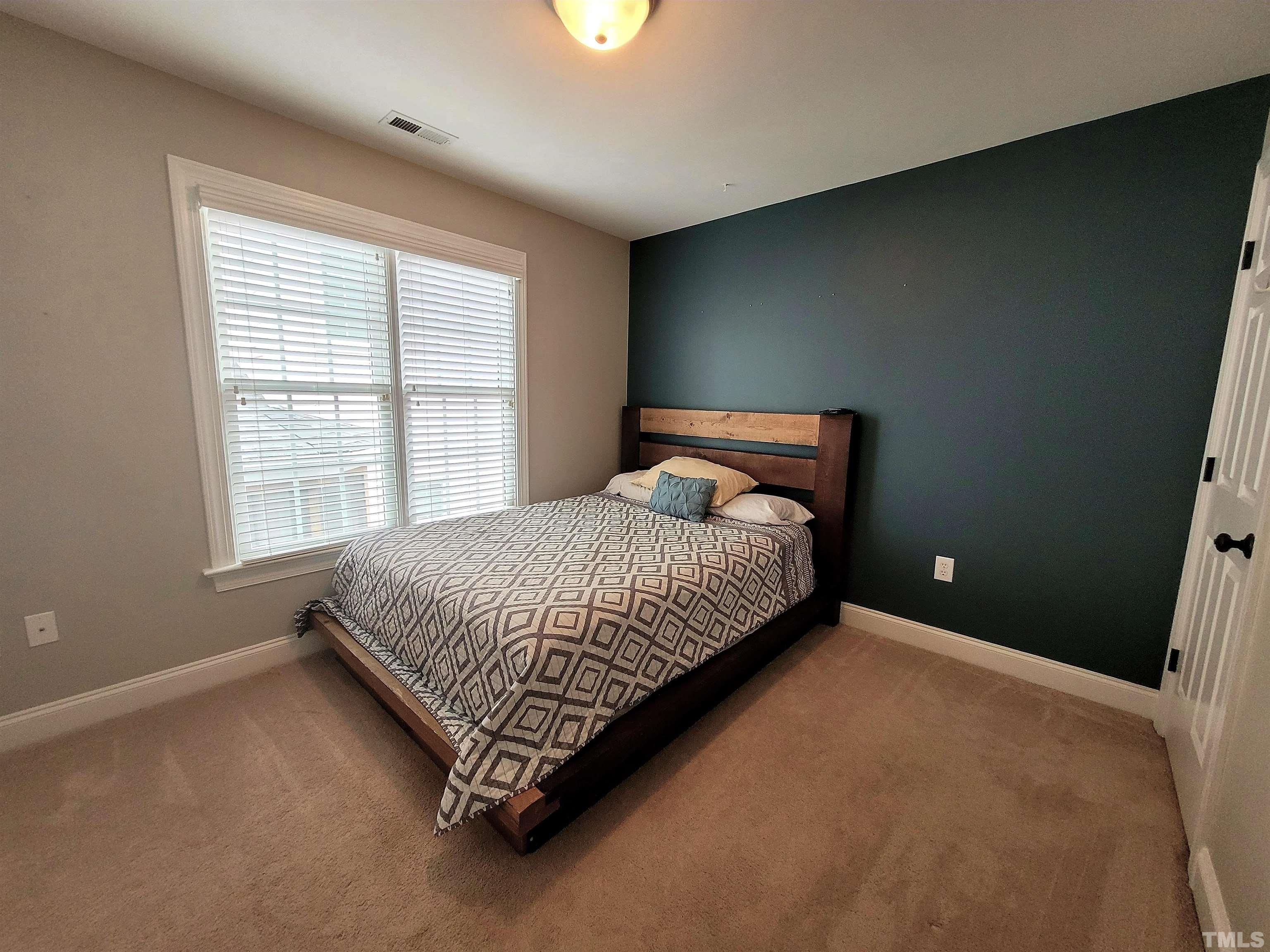 411 Magdala Place Apex, NC 27502 - Photo 10 of 29 a spacious bedroom with a bed and a window
