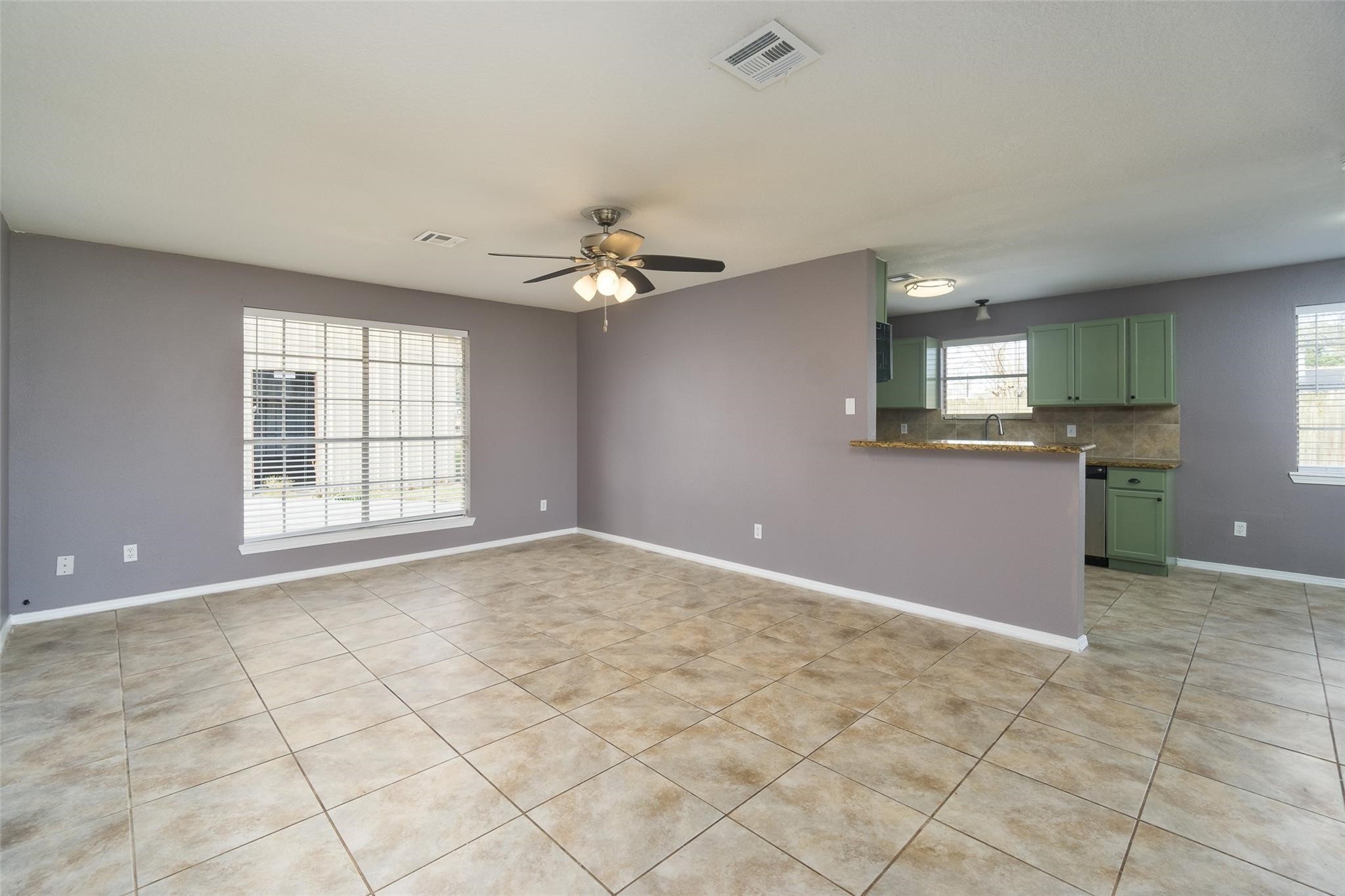 4604 South Tower Road Santa Fe, TX 77517 - Photo 4 of 28 an empty room with windows and chandelier fan