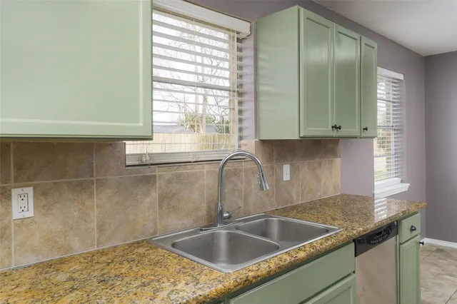 a view with granite countertop a sink and a window