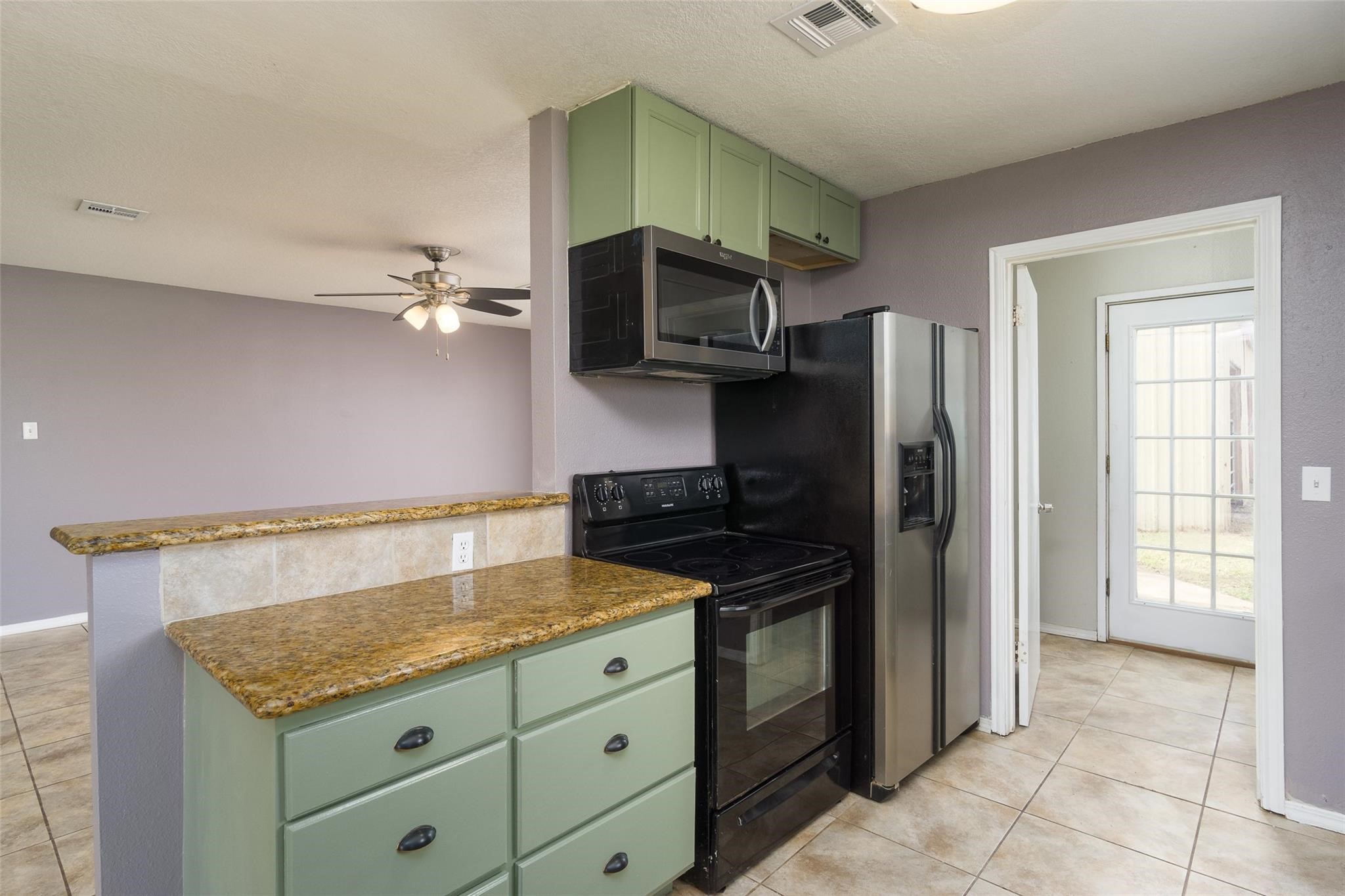 4604 South Tower Road Santa Fe, TX 77517 - Photo 10 of 28 a kitchen with granite countertop a stove and a refrigerator