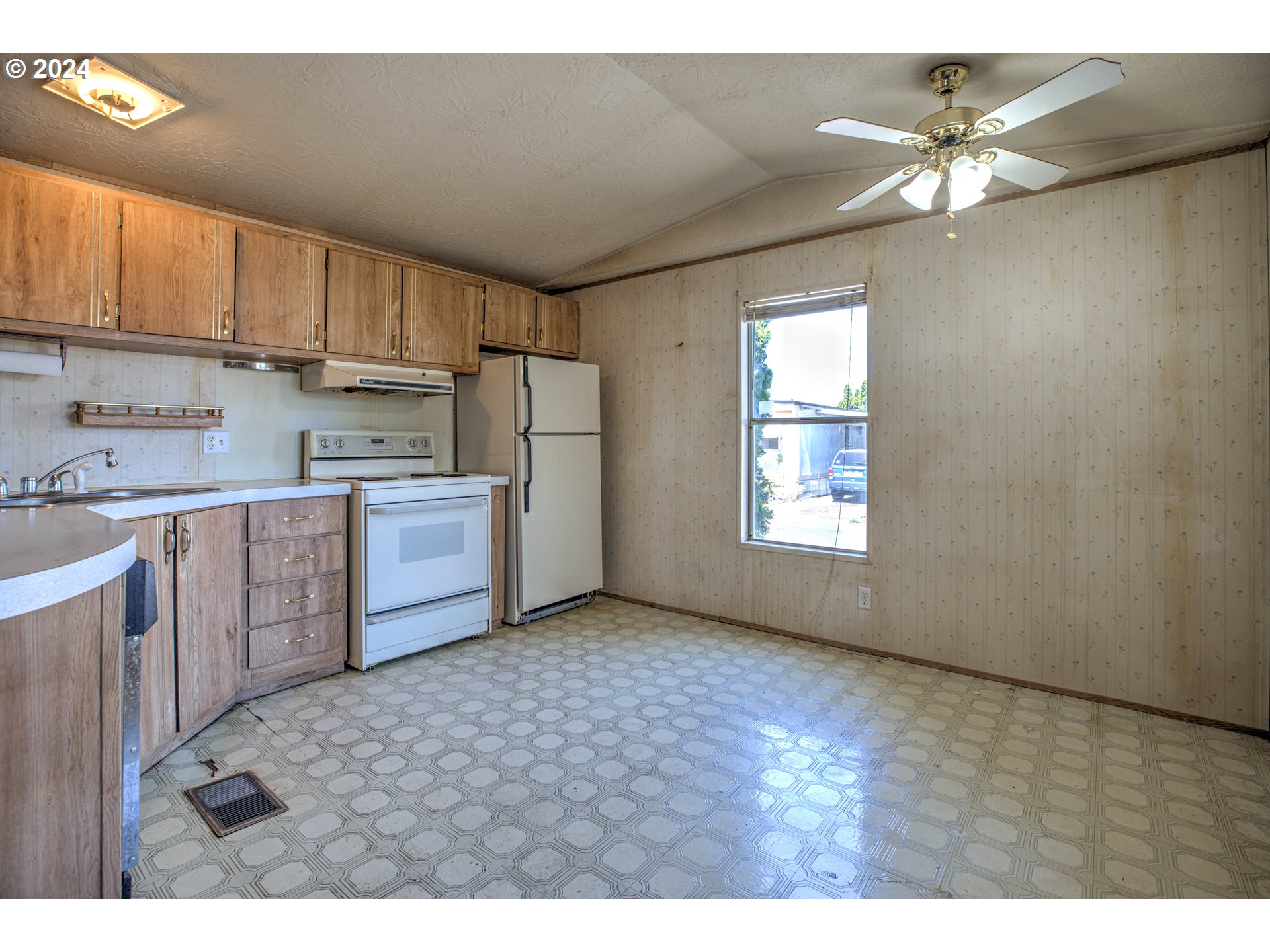 19605 River Road Gladstone, OR 97027 - Photo 12 of 21 a kitchen with stainless steel appliances a sink a stove a refrigerator cabinets and a window