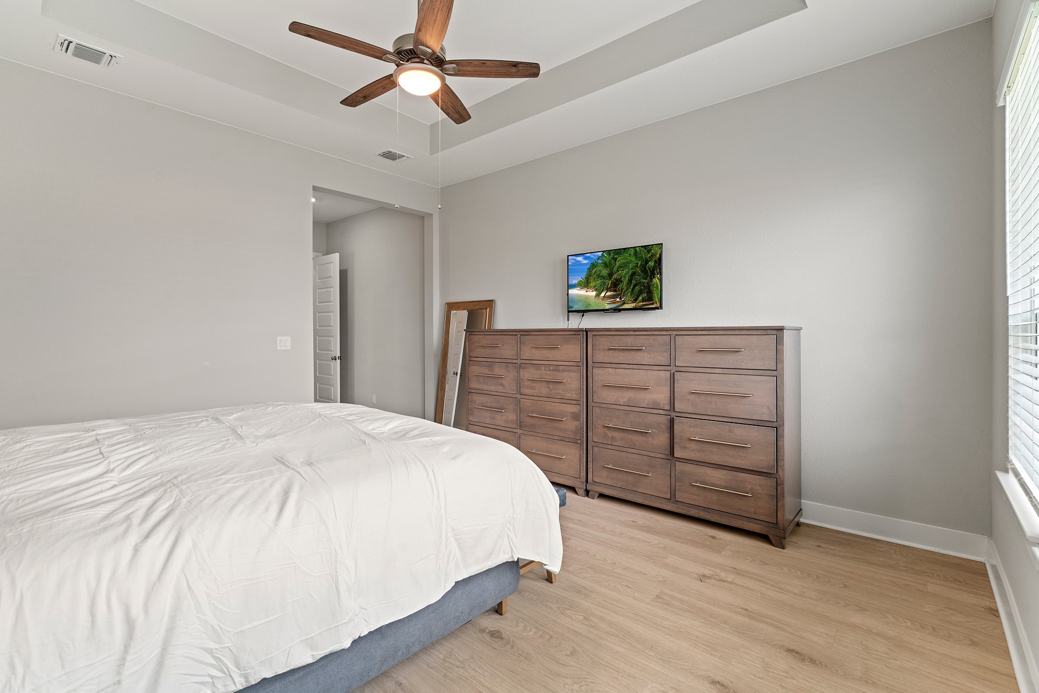 2112 Tobiano Trace Georgetown, TX 78633 - Photo 16 of 40 Bedroom with a raised ceiling, wood finished floors, and a ceiling fan