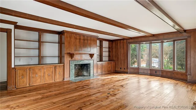 a view of an empty room with a fireplace and a window