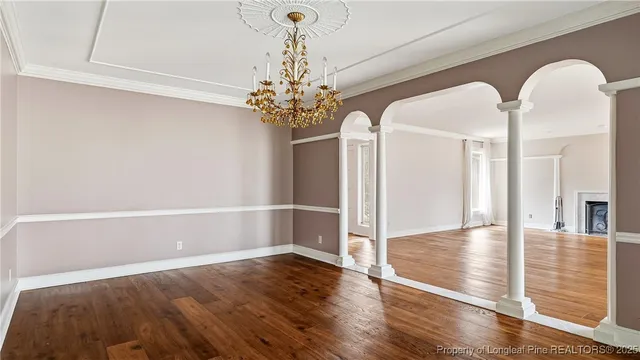 a view of a room with wooden floor and chandelier