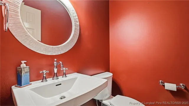 a bathroom with a sink mirror and toilet