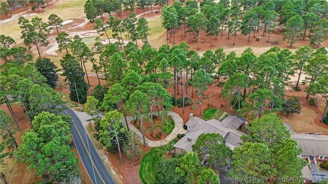 an aerial view of residential house with outdoor space and trees all around