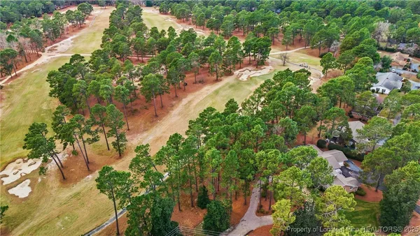 an aerial view of residential house with outdoor space and trees all around