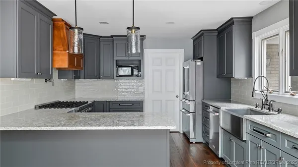 a kitchen with stainless steel appliances granite countertop a sink and a refrigerator