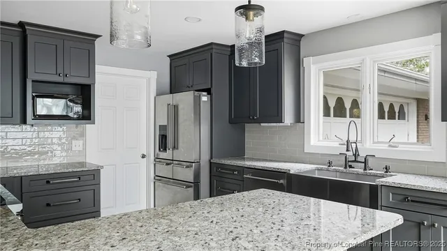 a kitchen with granite countertop a refrigerator and a stove