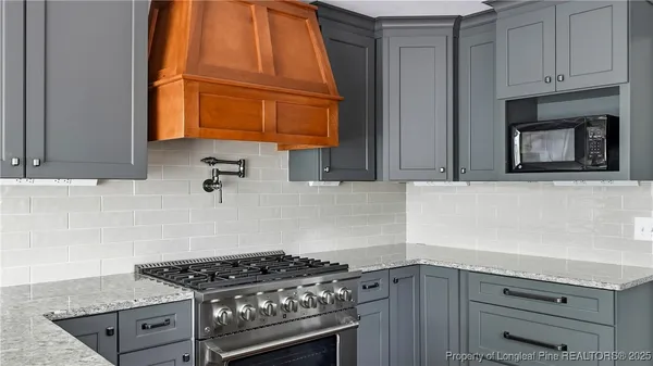 a kitchen with granite countertop a stove and a sink